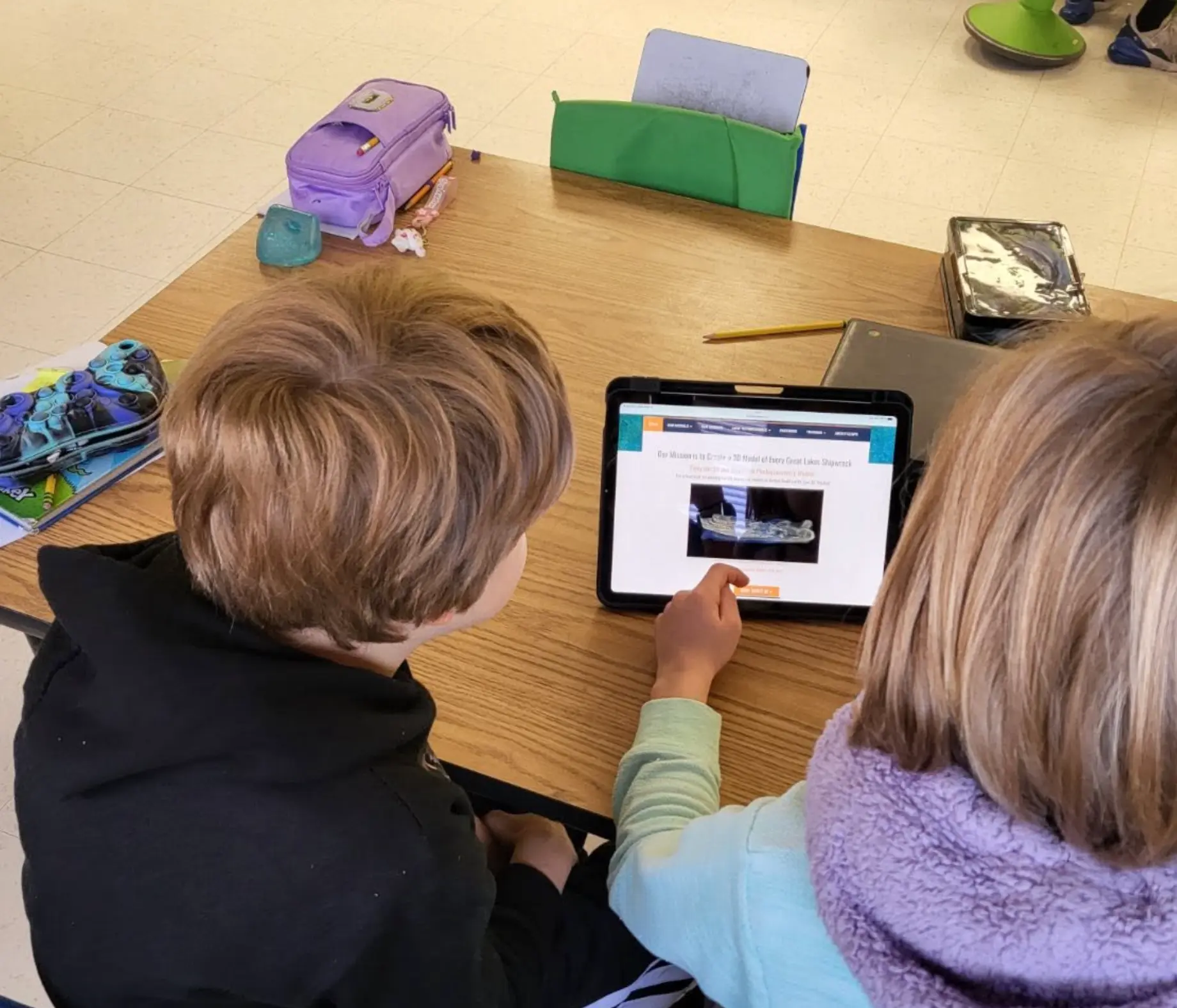 Two students examining a model on a tablet during a Project GL session